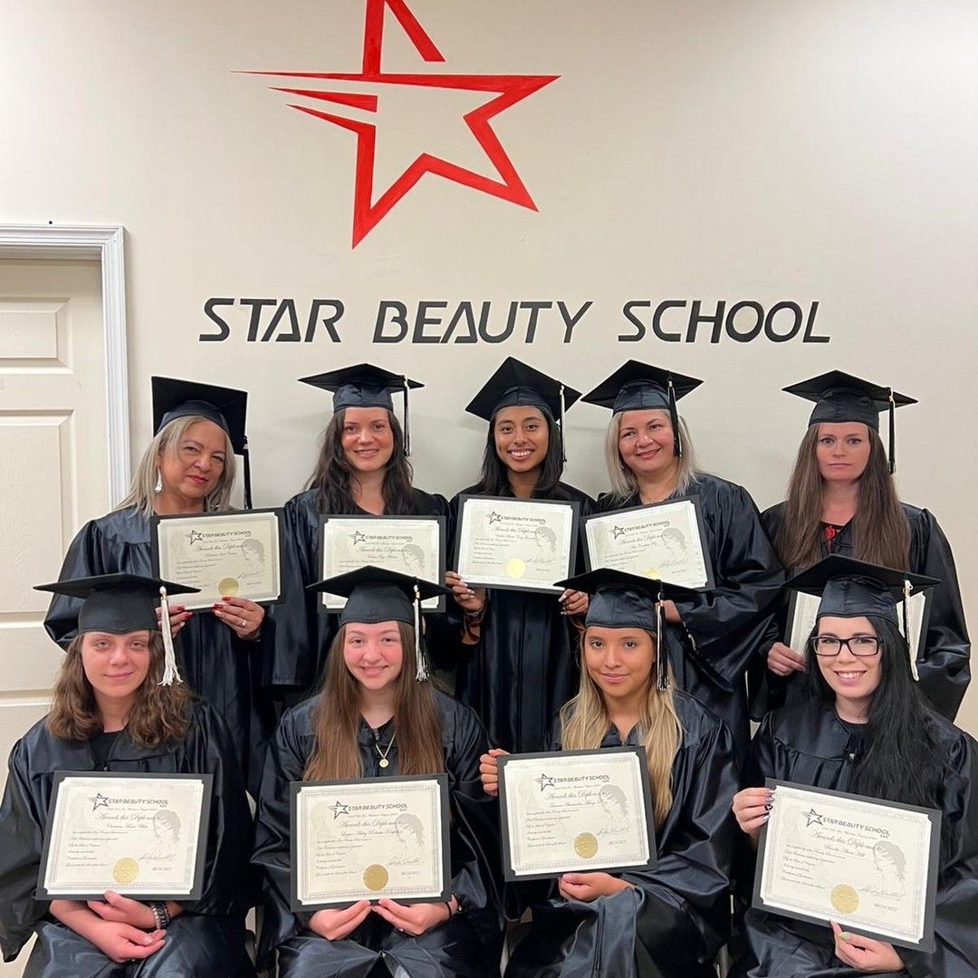 A group of graduates are posing for a picture in front of a wall that says star beauty school.