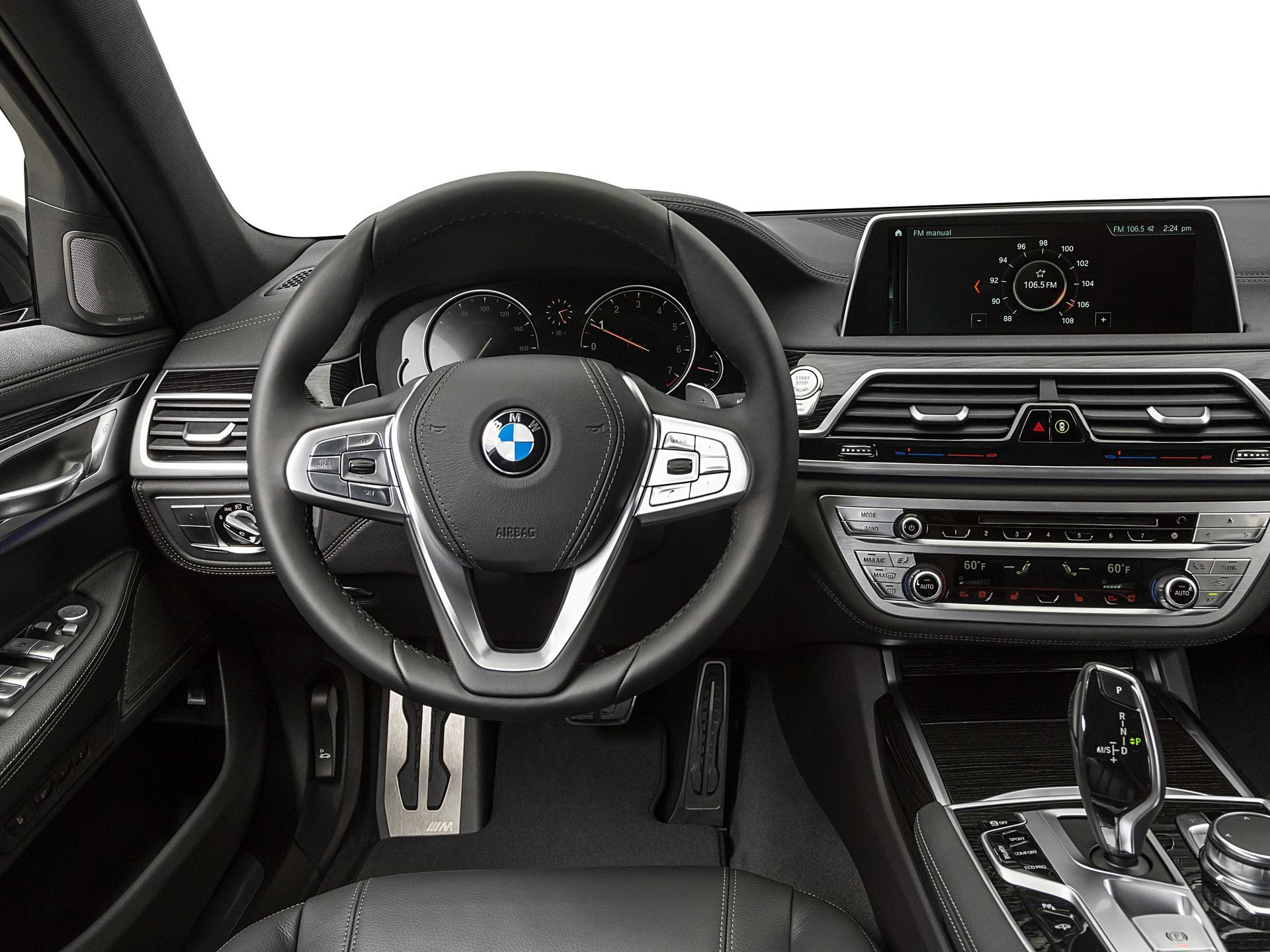 Interior view of a black leather BMW dashboard, steering wheel, and center console featuring a digital display screen.