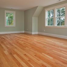An empty room with light hardwood floors