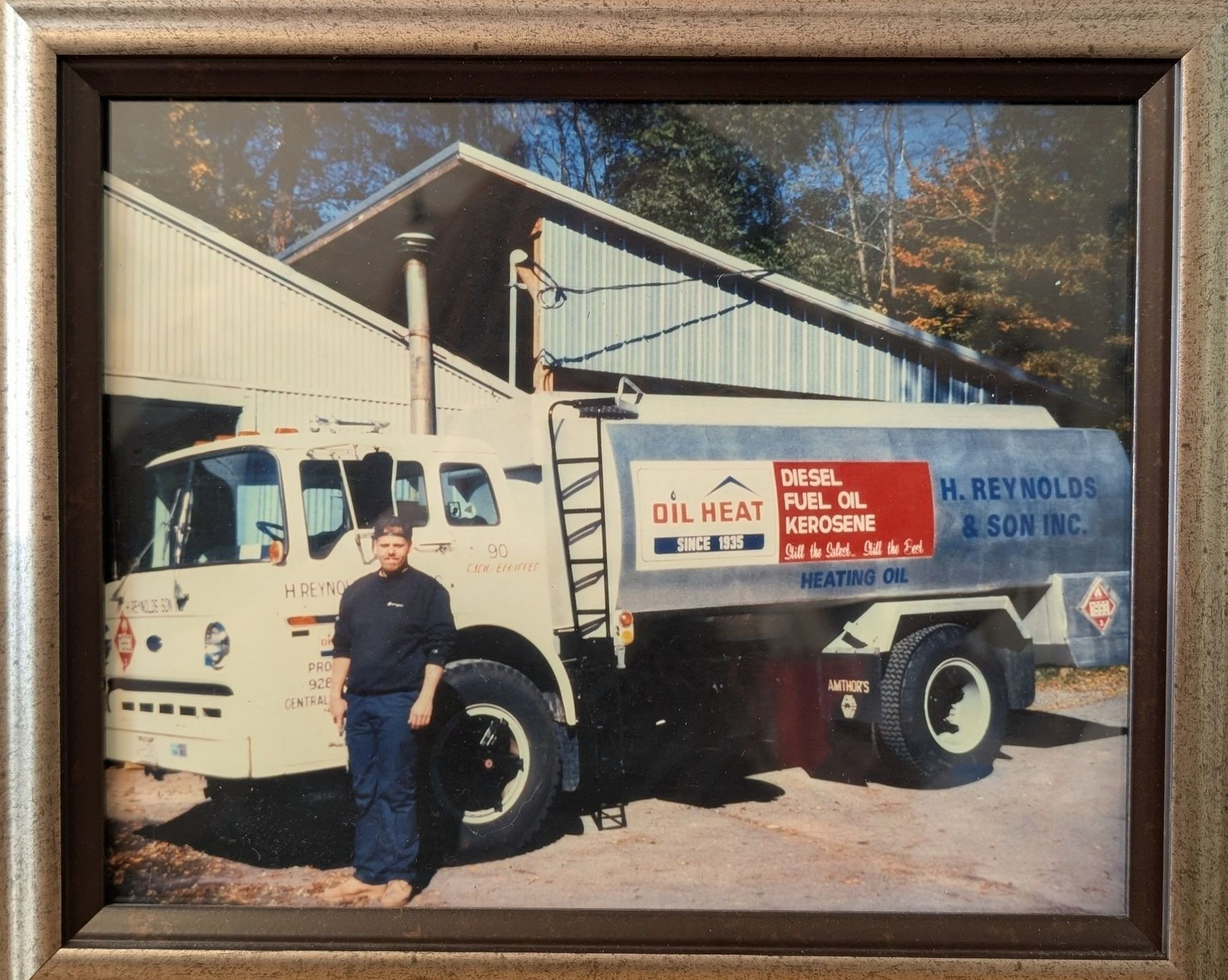 A man stands in front of a truck that says oil heat