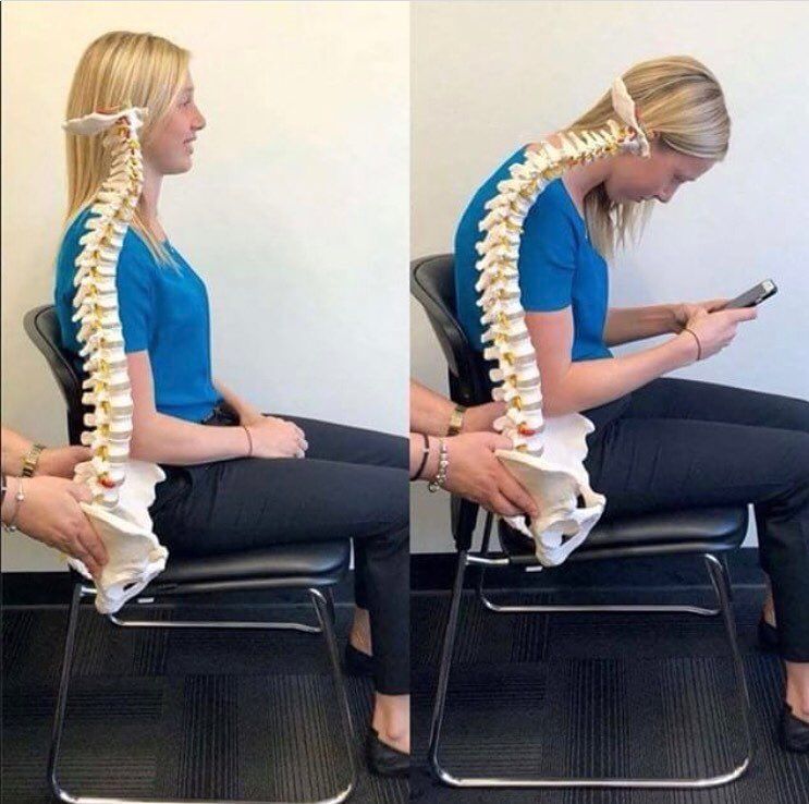 A woman sitting in a chair with a model of her spine