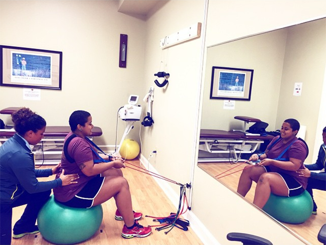 A woman is sitting on a green exercise ball in front of a mirror.