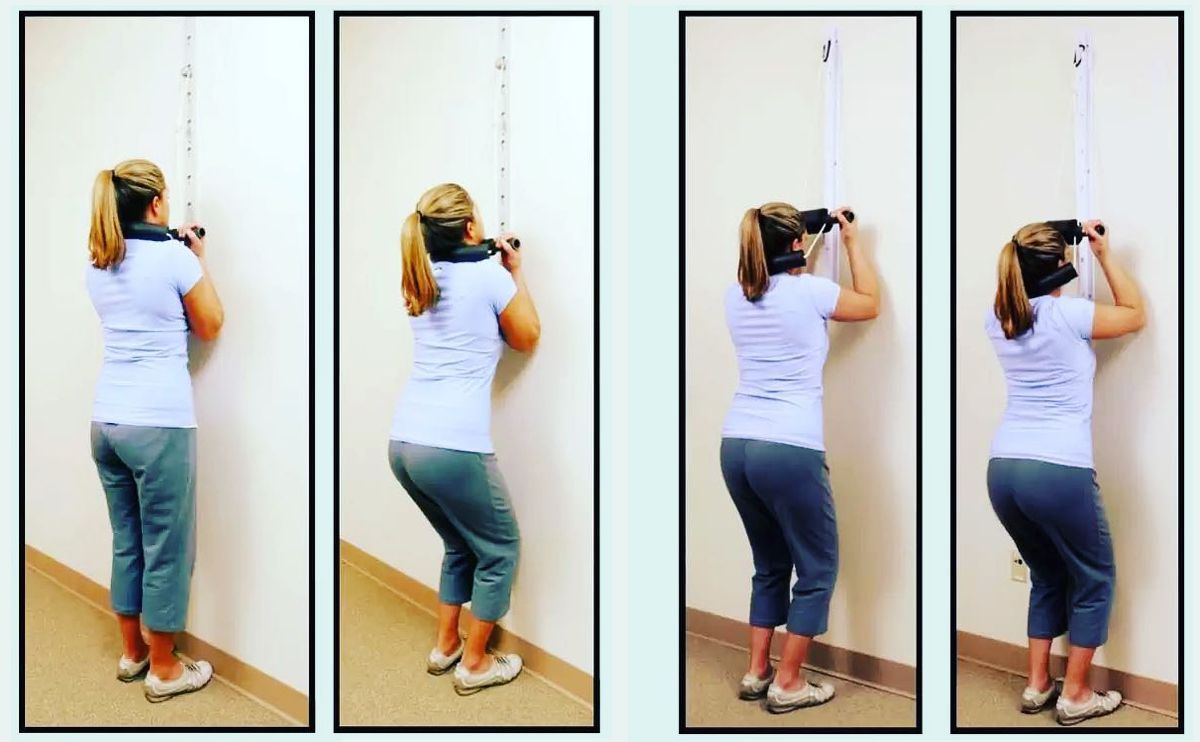 A woman is doing exercises on a wall with a rope