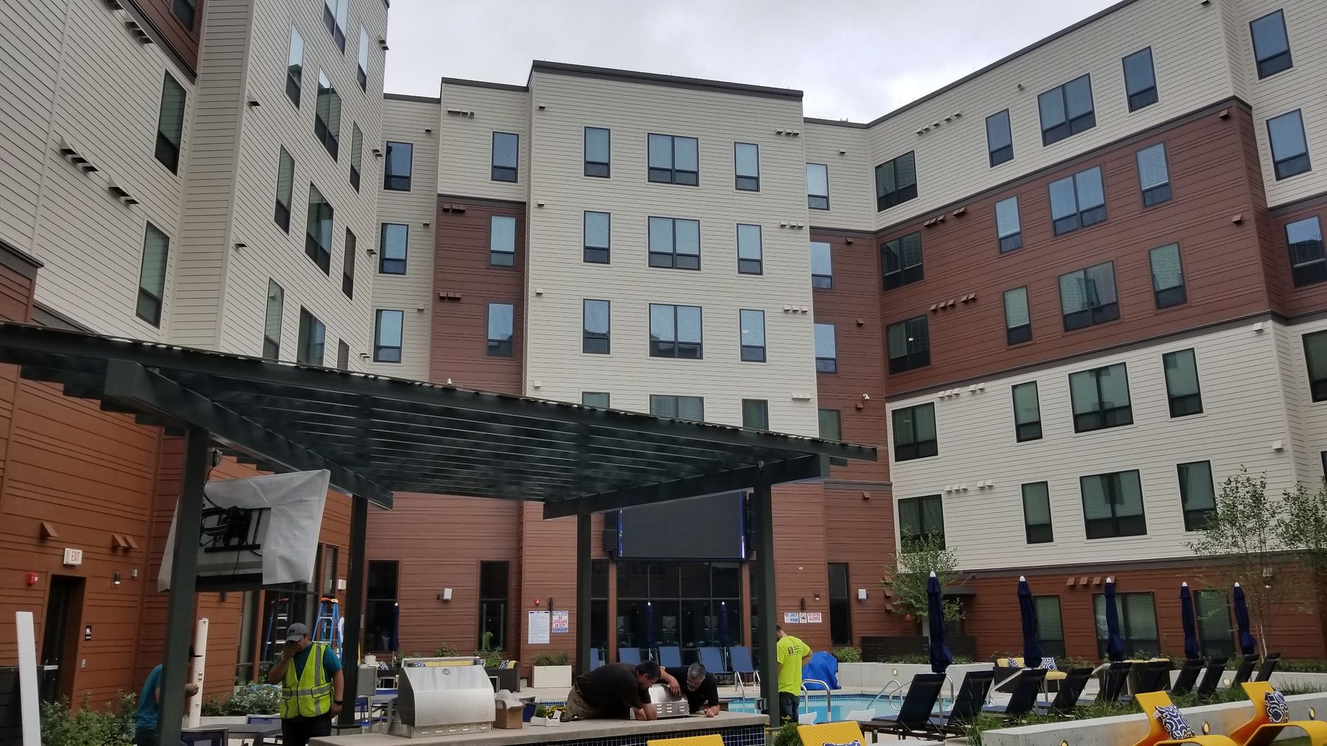 A large apartment building with a swimming pool in front of it.