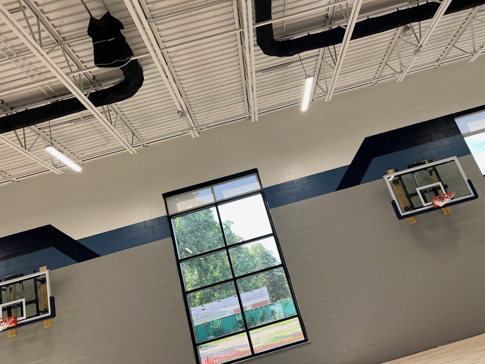 A basketball hoop is hanging from the ceiling of a gym.