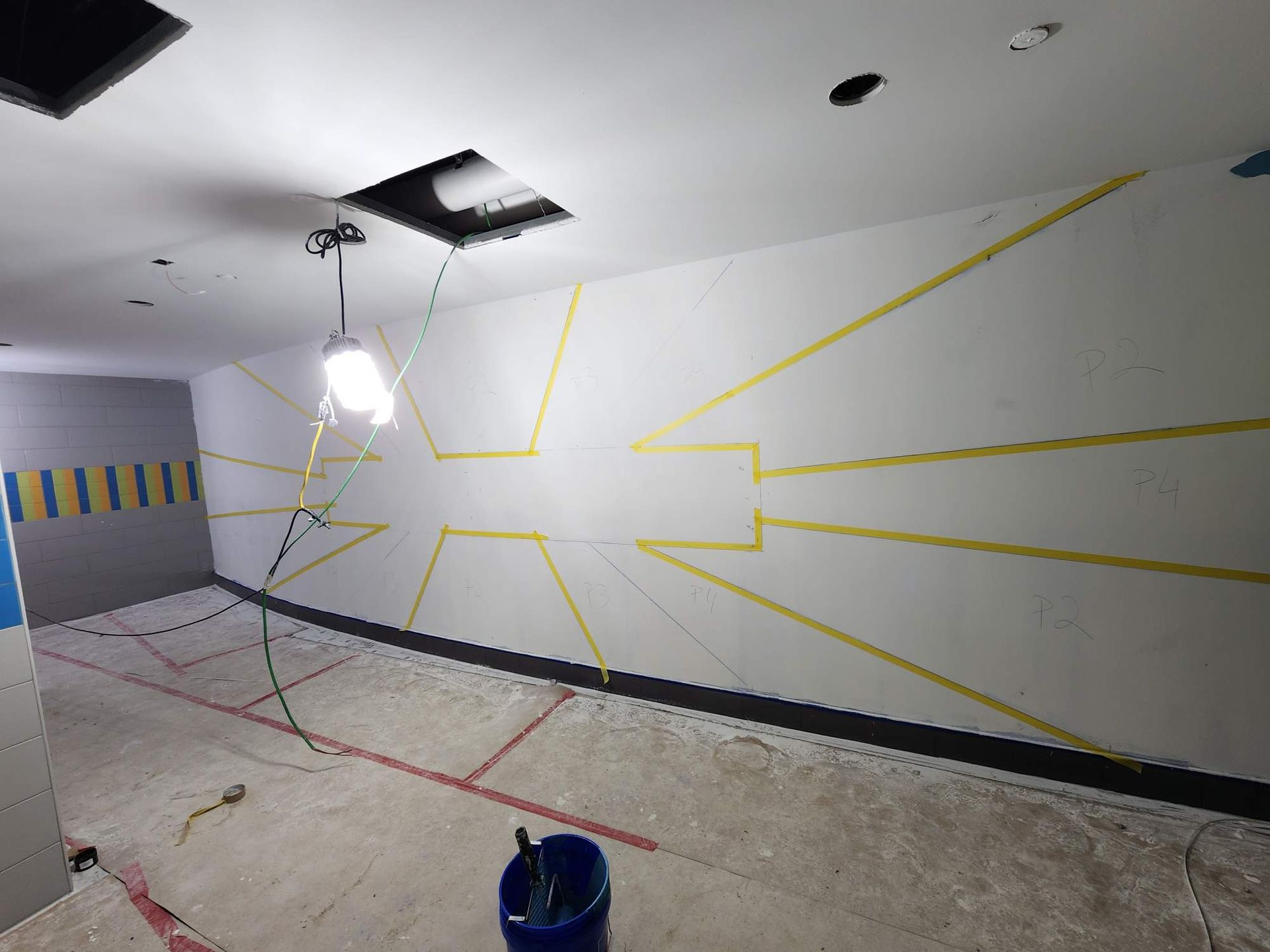 A room with a bucket of paint and a light on the ceiling