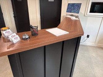 reception desk with a wood-tone countertop and black metal base