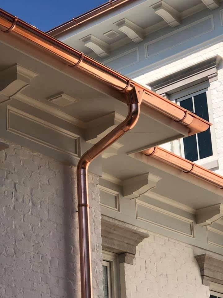 copper gutters and downspout on a white brick building