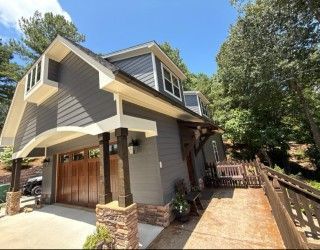 two-story gray house with a wooden garage door