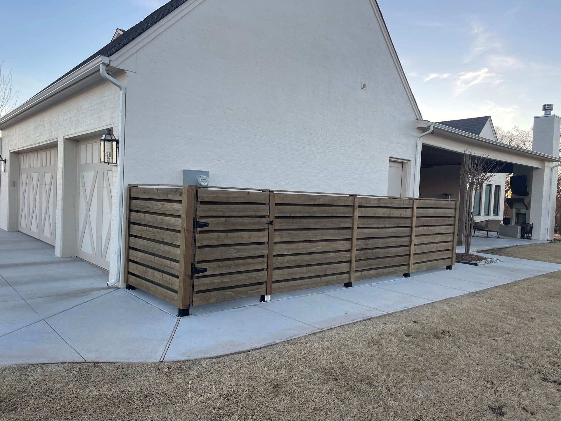 A white house with a wooden fence in front of it