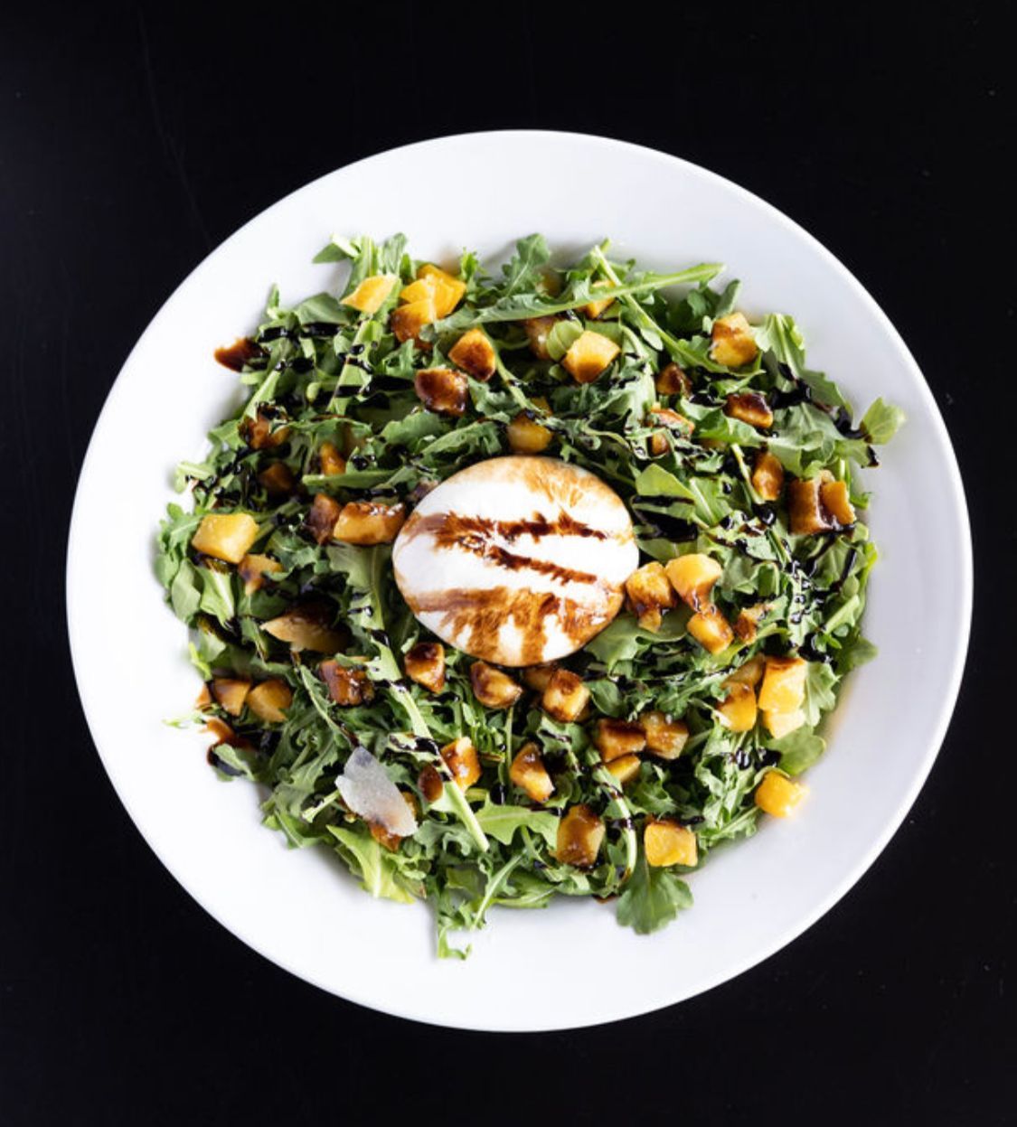 A salad with a poached egg on top of it.