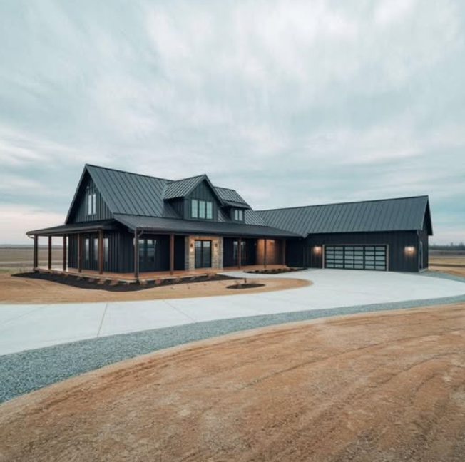 Modern black farmhouse with a wrap-around porch and driveway.