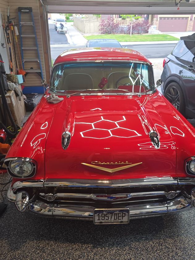 Red classic Chevrolet parked in a garage, front view with chrome details and glossy finish