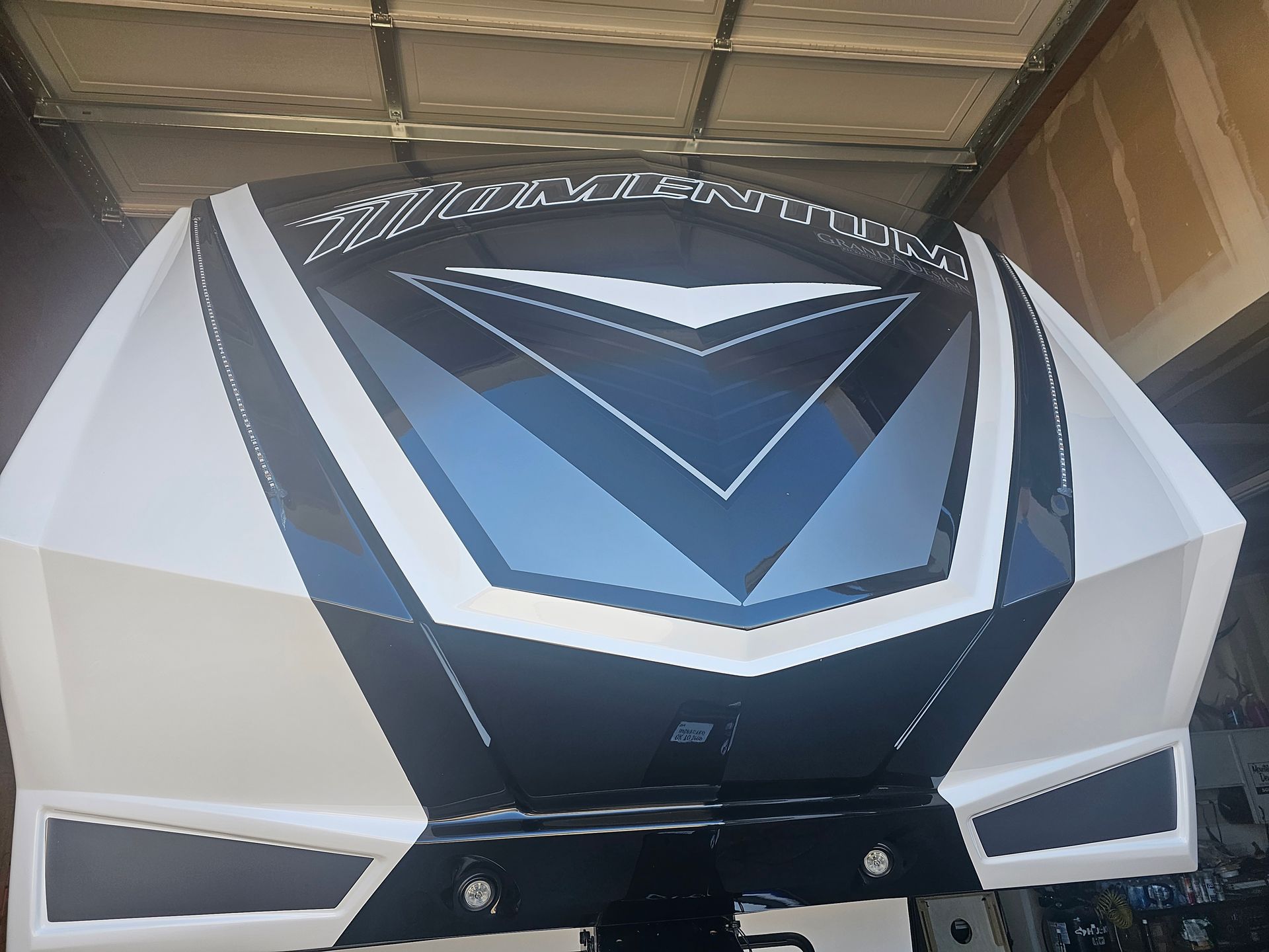 White-and-black futuristic vehicle front with blue V-shaped accents inside a garage