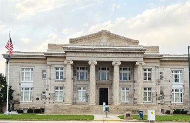 A large building with columns and a flag in front of it