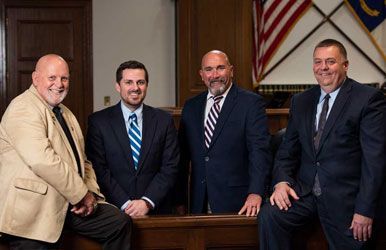 A group of men in suits and ties are posing for a picture.