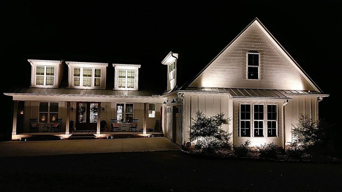 A beautiful large white house is lit up at night