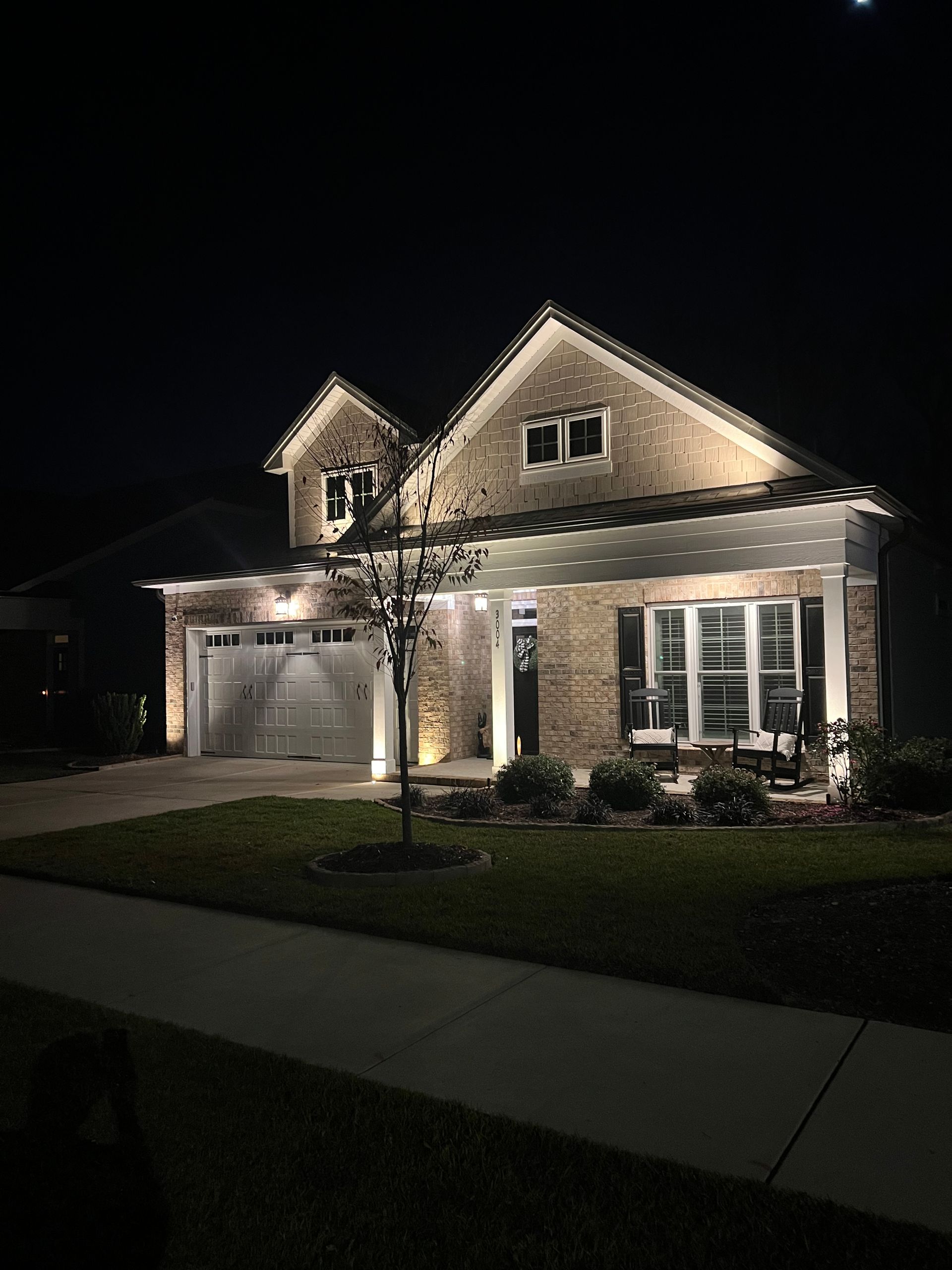 A large brick house is lit up at night.