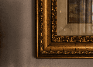 The corner of a picture in a gold frame.