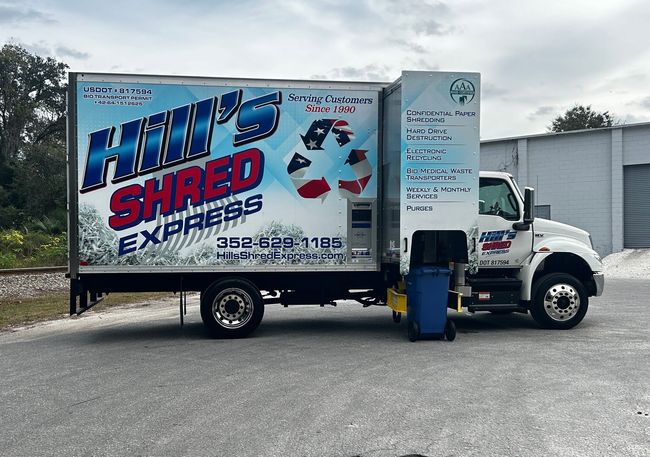 A hill 's shred express truck is parked in a parking lot