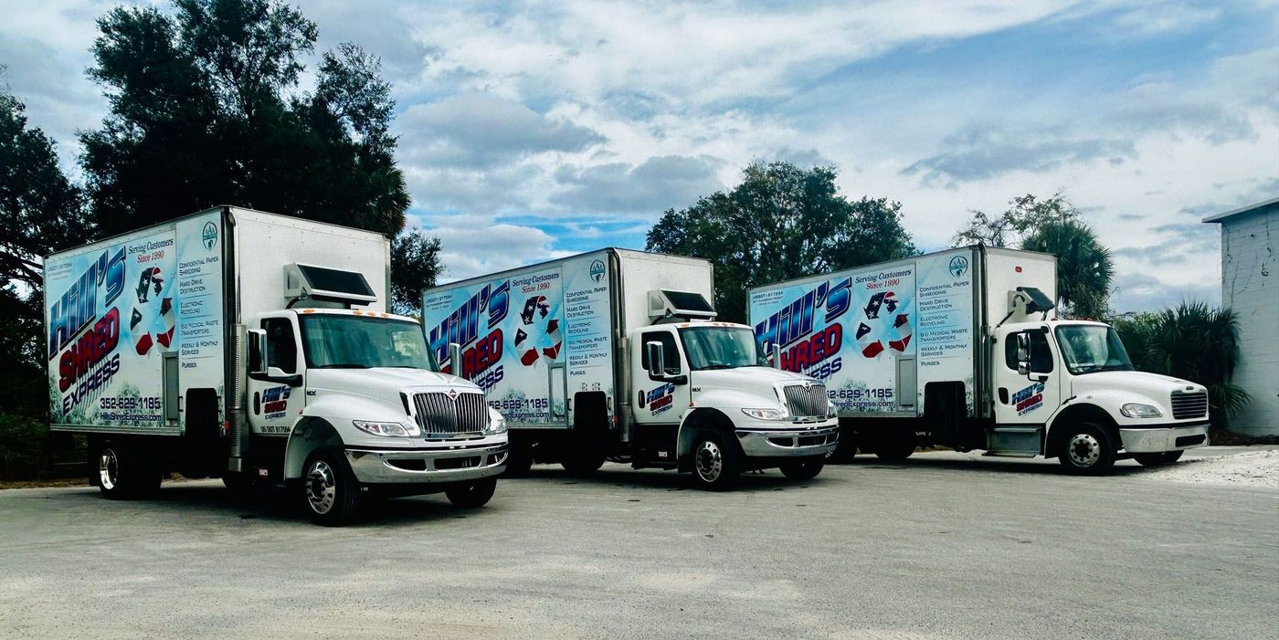 Three moving trucks are parked next to each other in a parking lot.