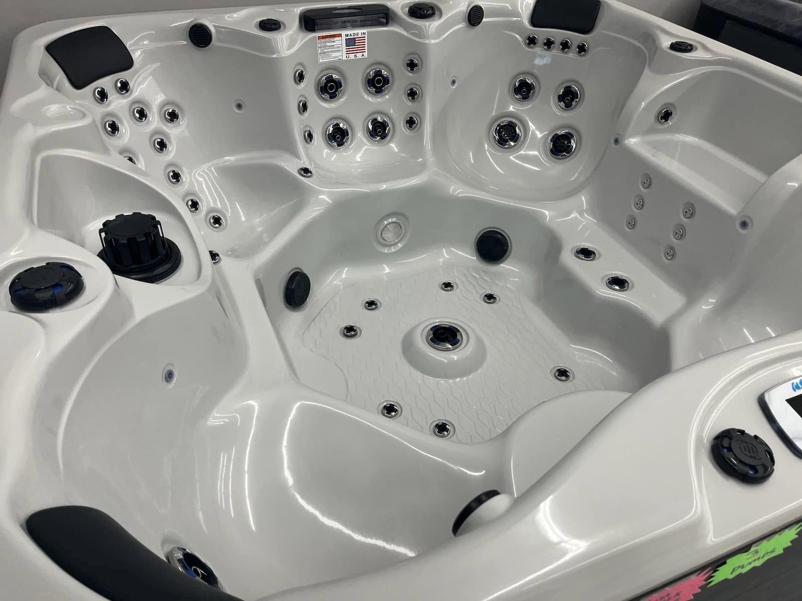 White multi-seat hot tub with jets and black headrests, viewed from above