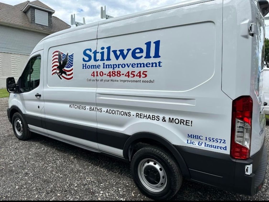 White van with Stilwell Home Improvement logo and contact info parked outdoors.