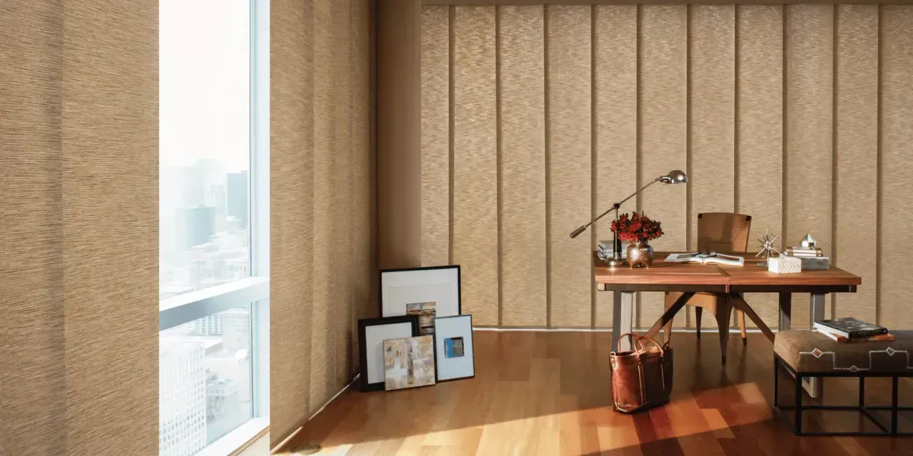 Interior view of a home office with natural light. A wooden desk with a leather briefcase sits next to a window.