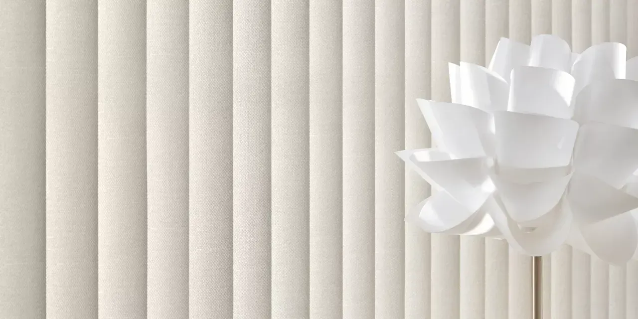 White vertical blinds with a white flower-shaped light fixture on the right.