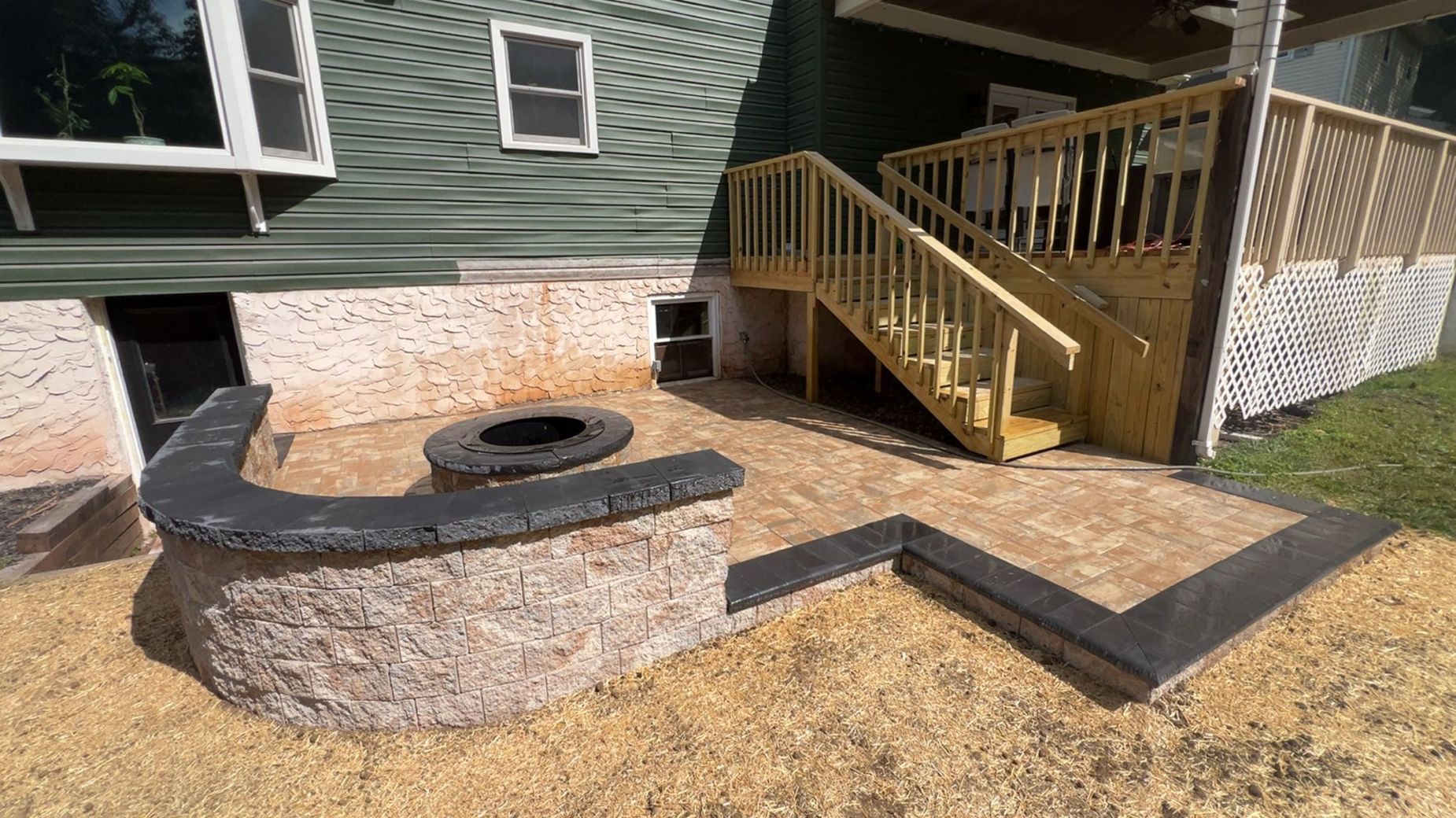 Patio with built-in fire pit, stairs, and retaining wall. Exterior of a house.