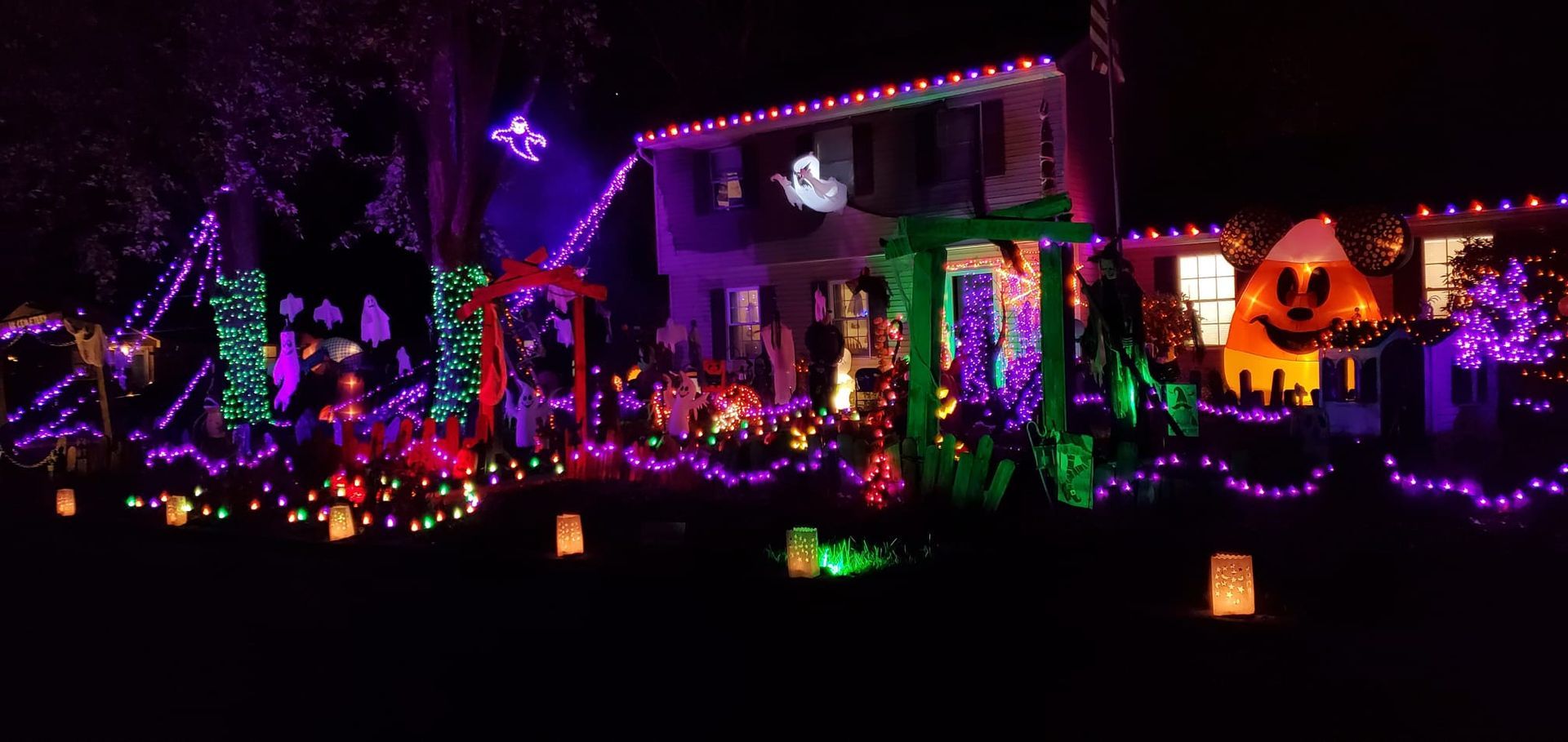 A house decorated with Halloween lights and decorations at night.