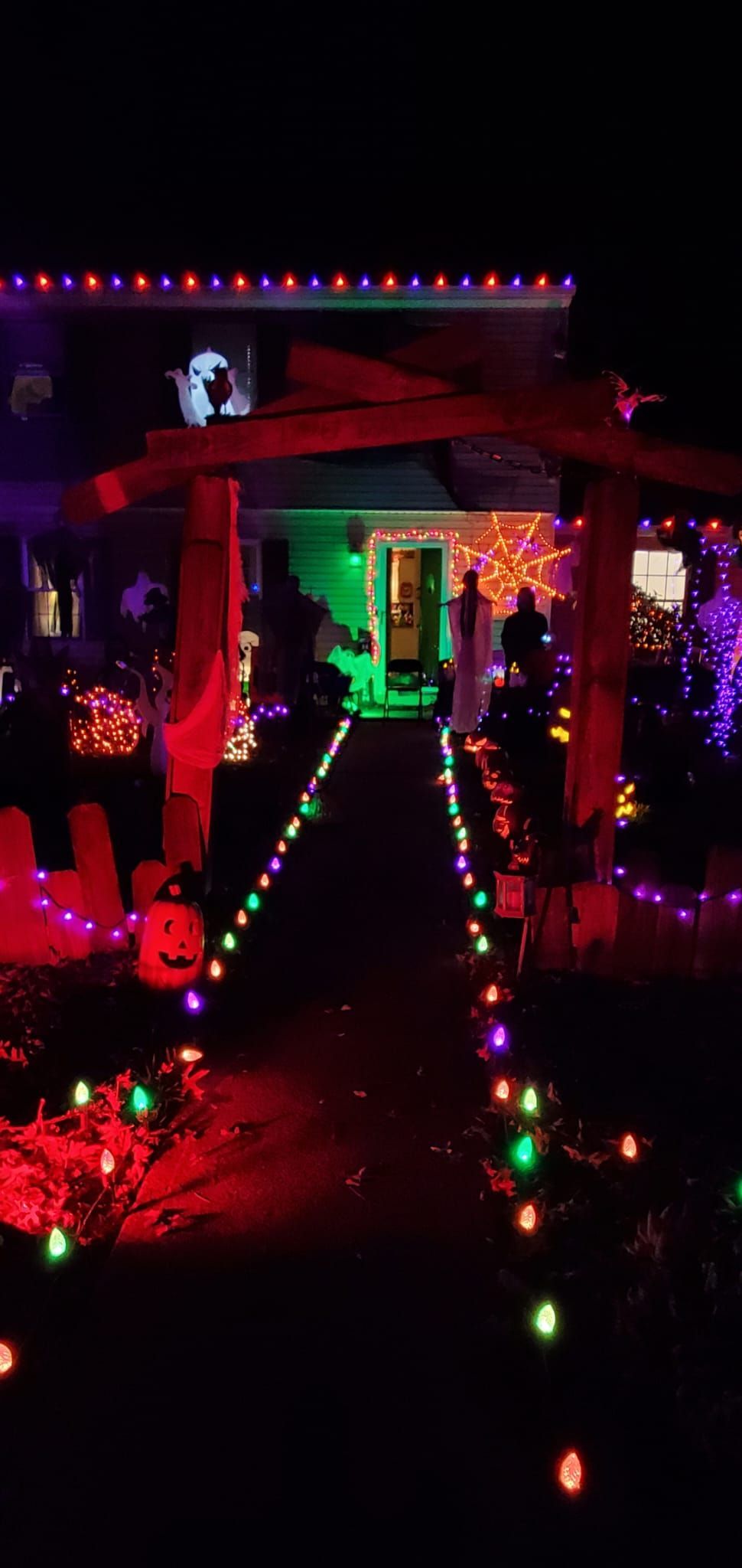 A house decorated with Halloween lights at night.