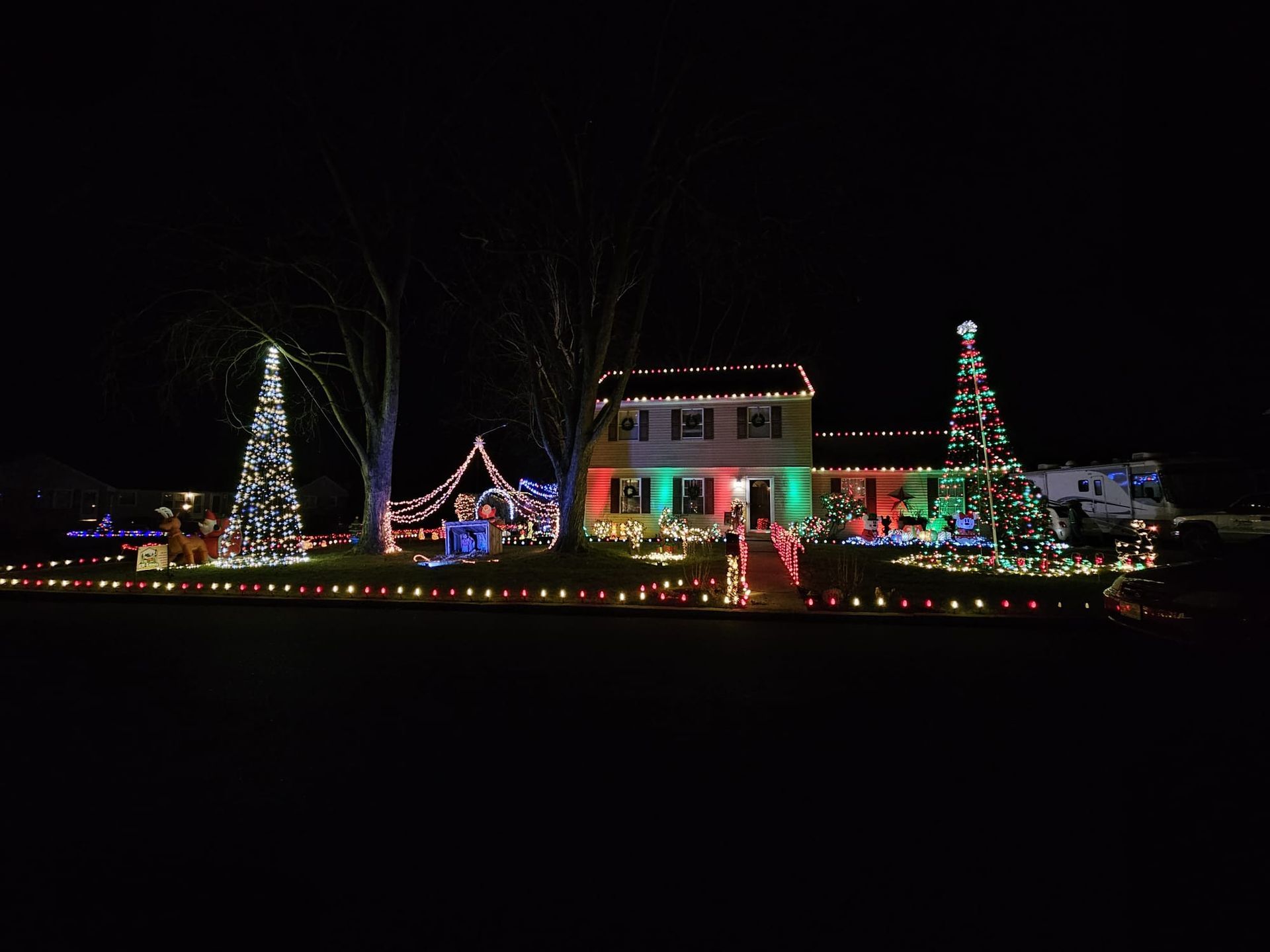 House decorated with bright Christmas lights at night.
