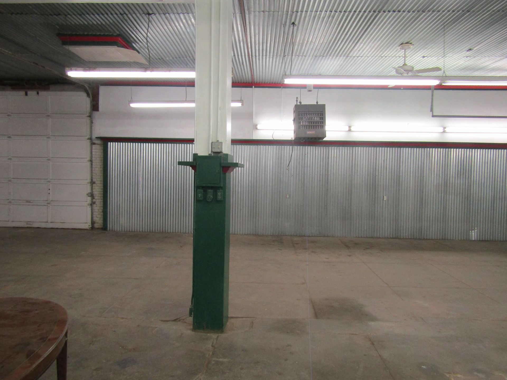 An empty room with a green pole in the middle