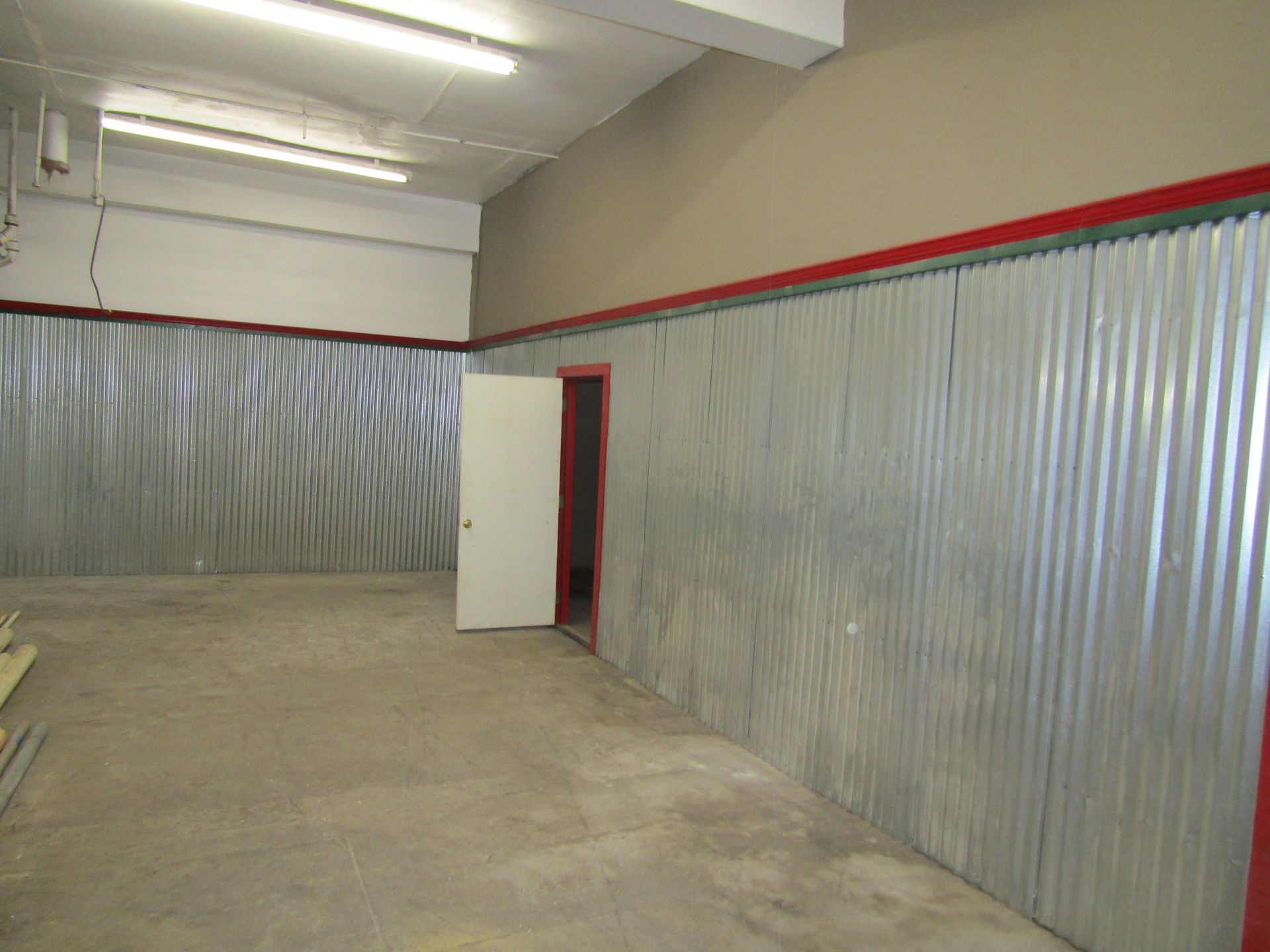 An empty room with a metal wall and a door