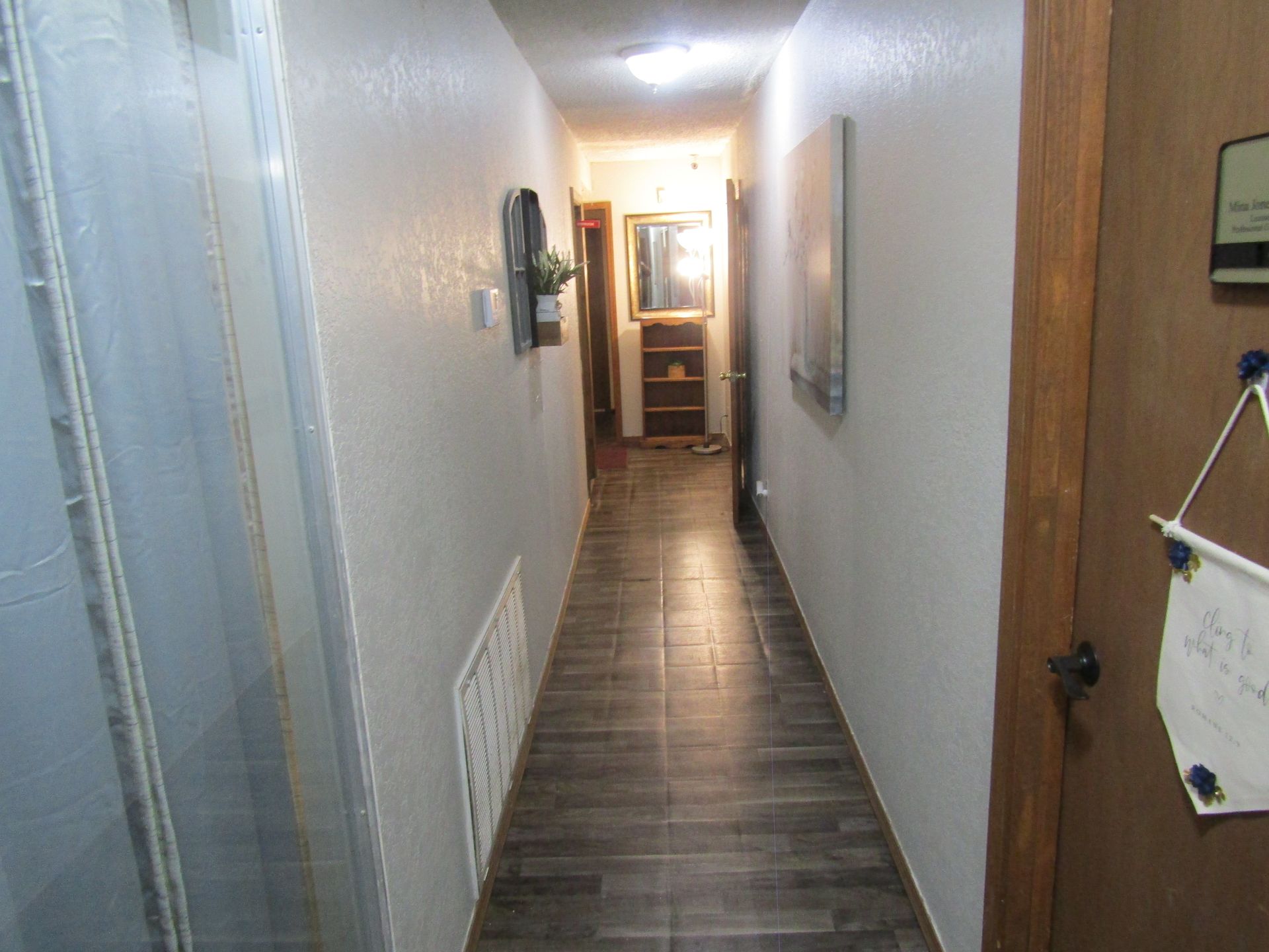 A long hallway with a sign hanging on the wall