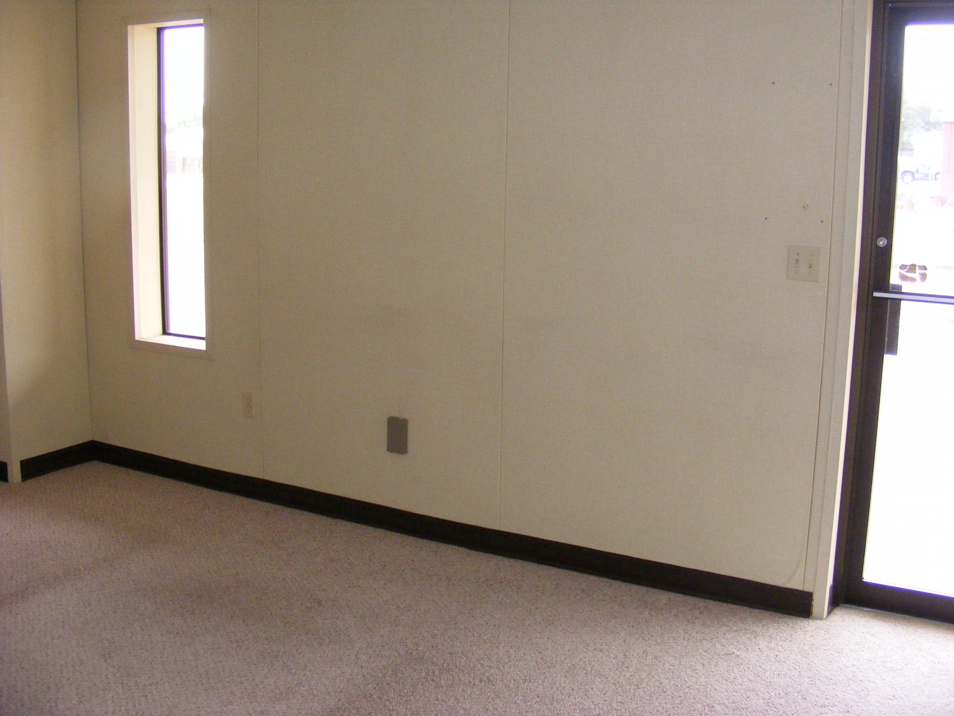 An empty room with a window and a door.