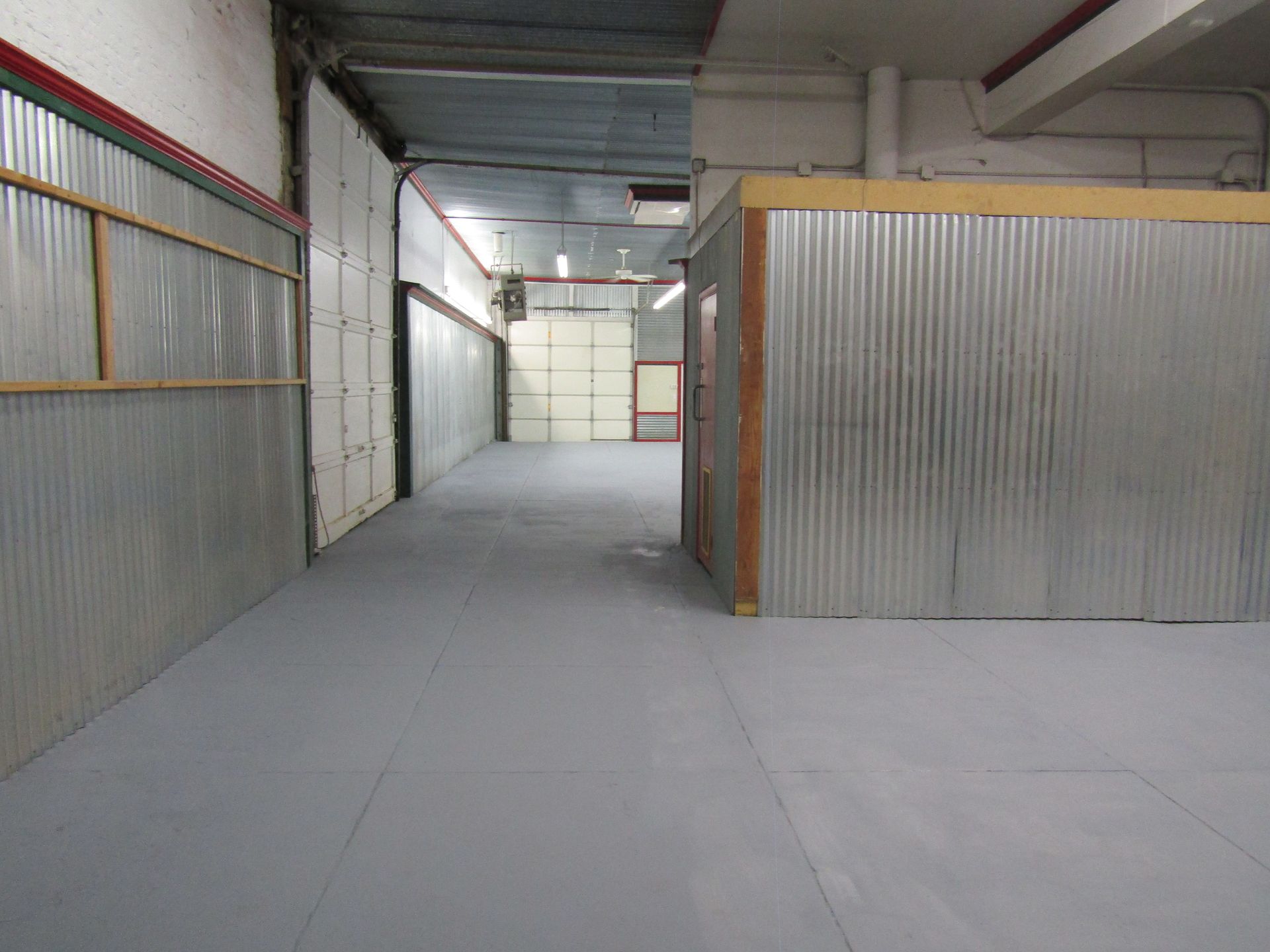A long hallway in a building with a metal wall