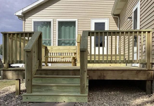 A house with a wooden deck and stairs leading to it