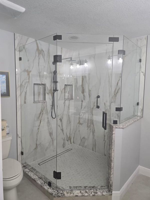 A bathroom with a walk in shower and a toilet.
