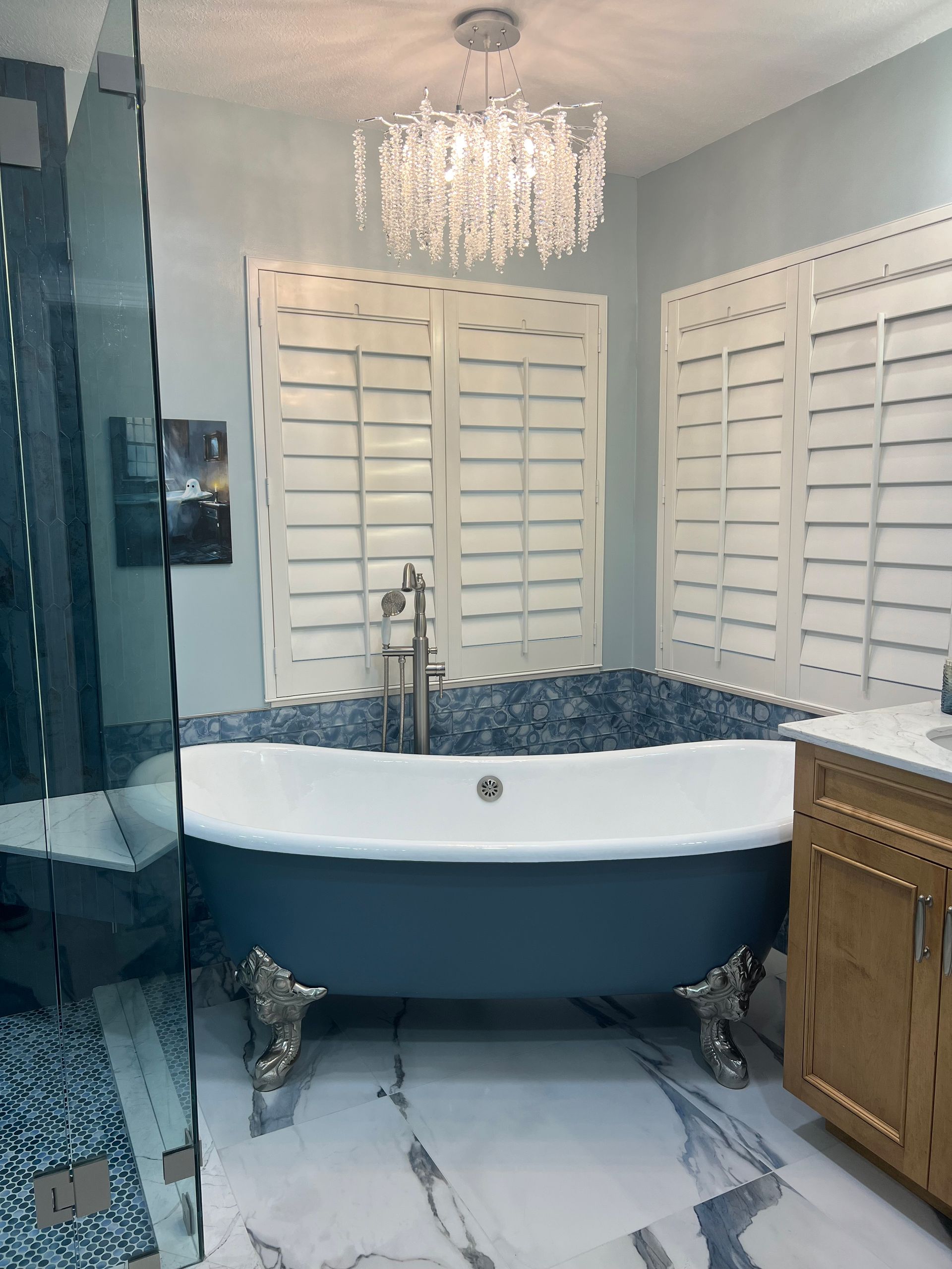 A bathroom with a bathtub and a chandelier hanging from the ceiling.
