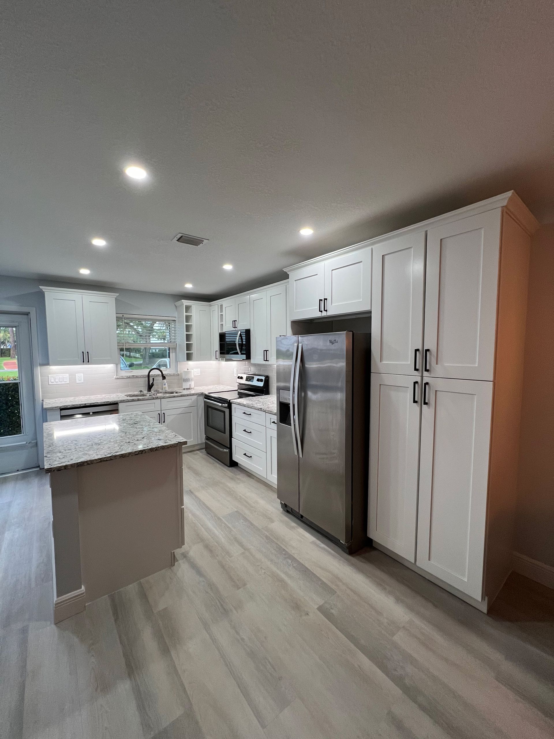 A kitchen with stainless steel appliances and white cabinets.