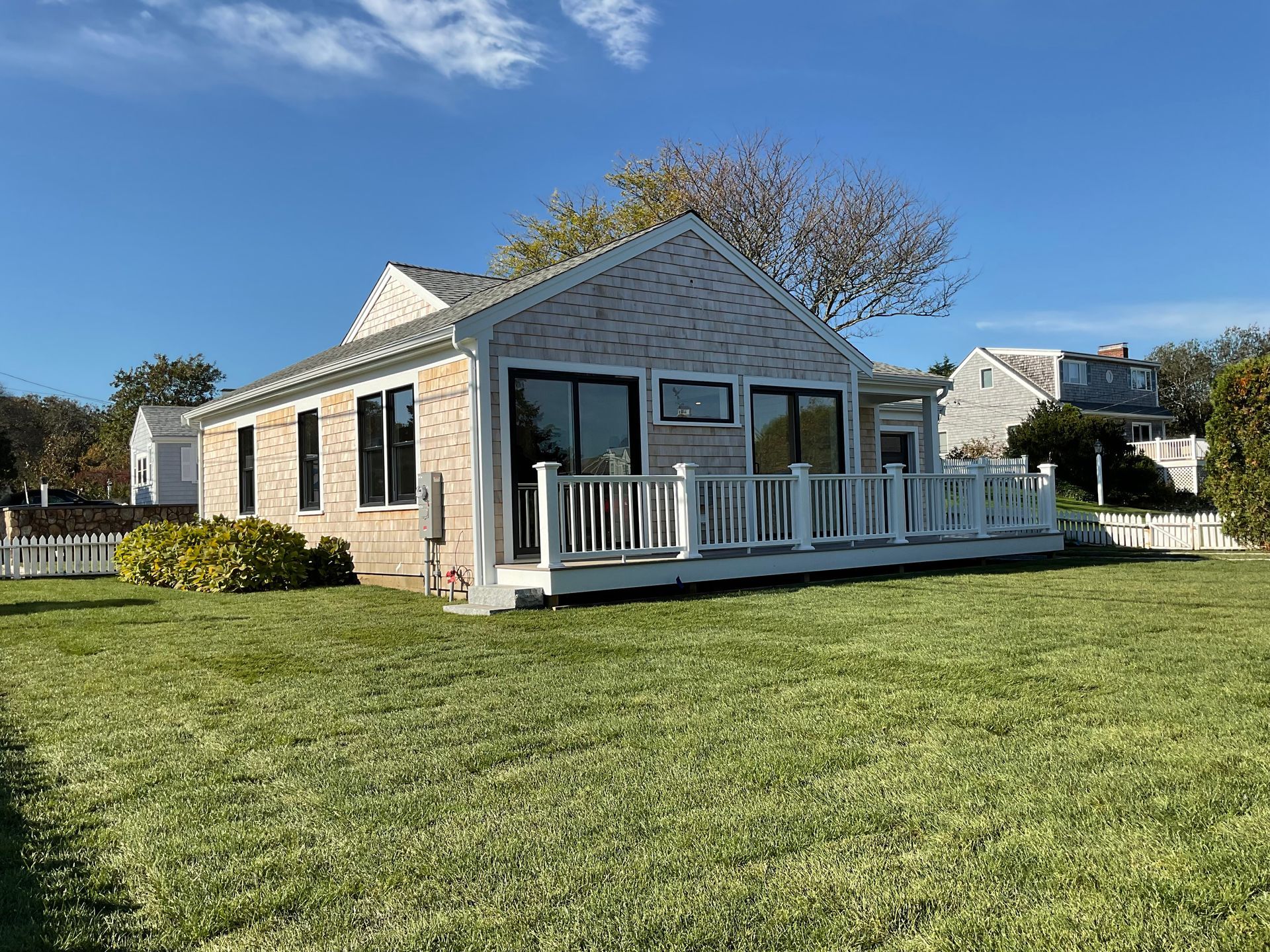 A small house with a large lawn in front of it