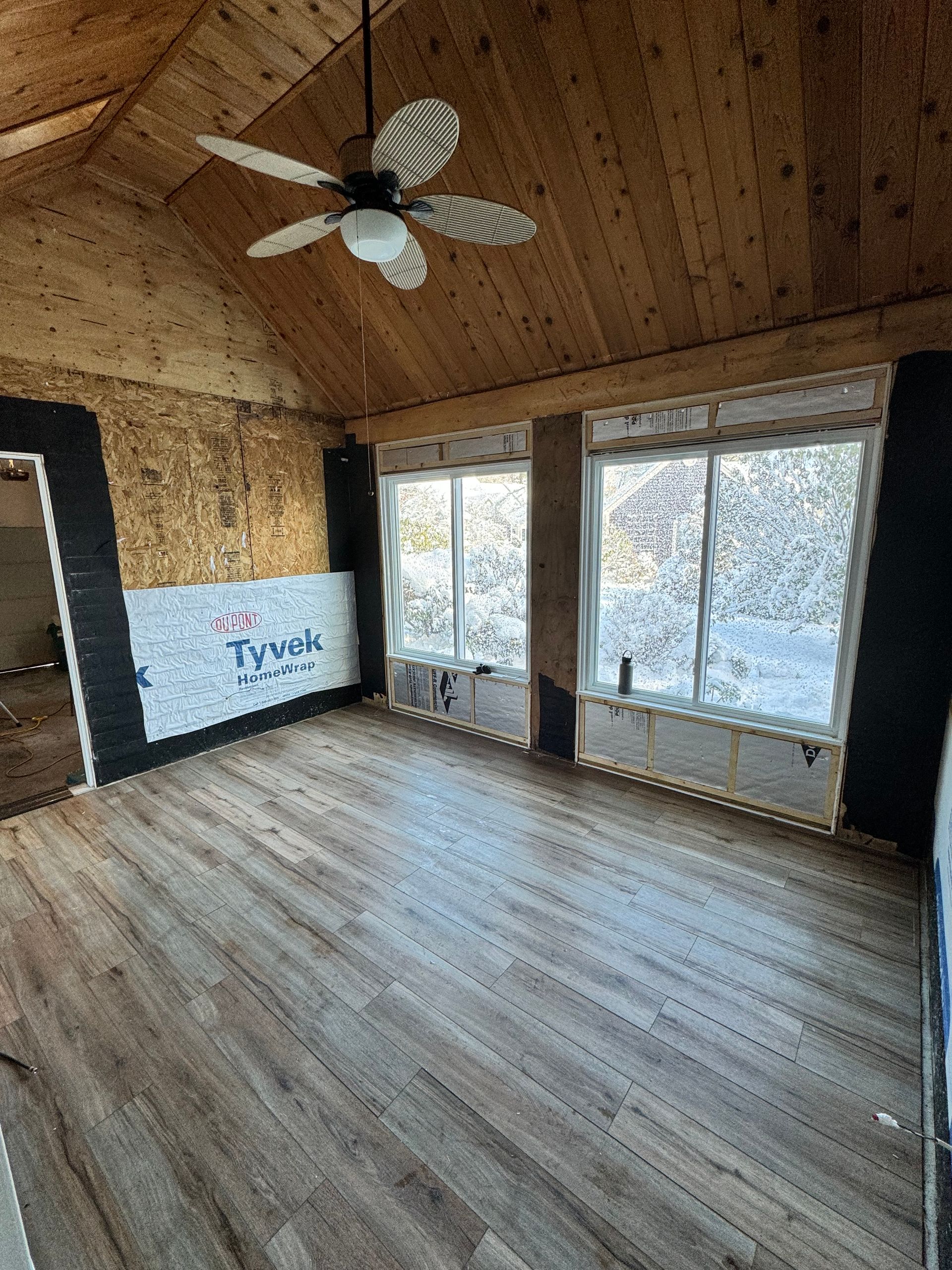 A large room with hardwood floors and a ceiling fan