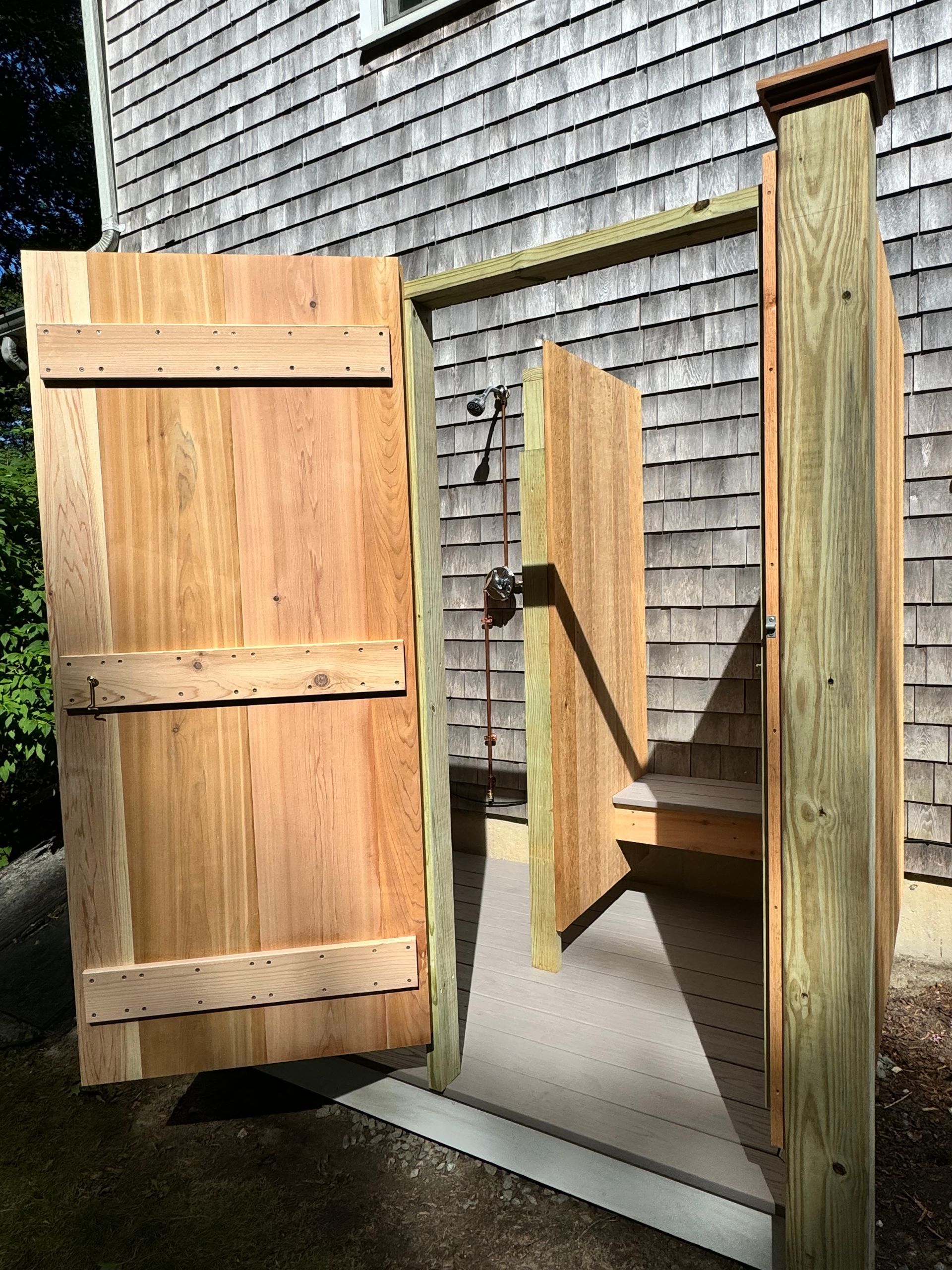 A wooden gate is open in front of a brick building