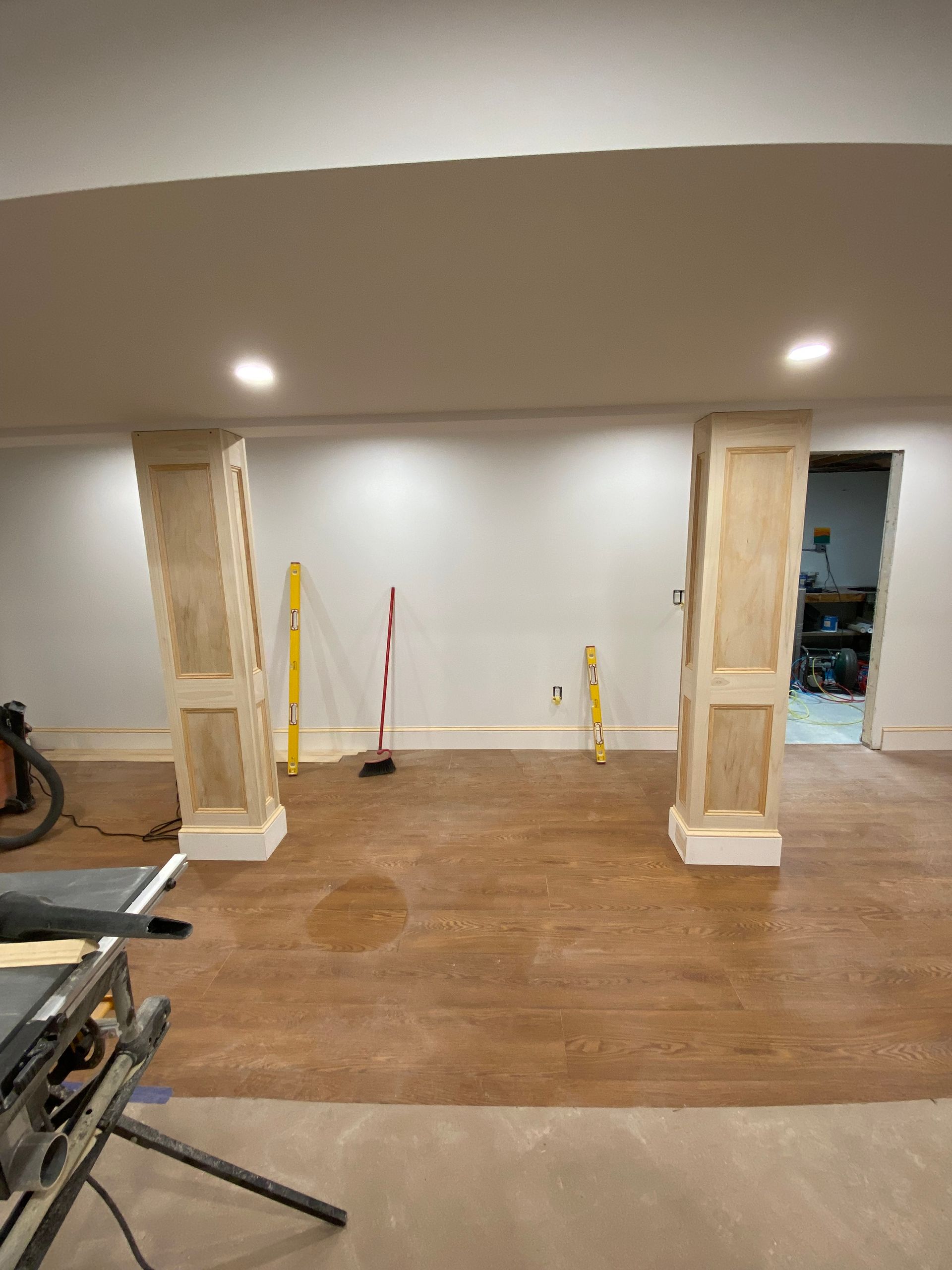 A basement with wooden columns and a wooden floor