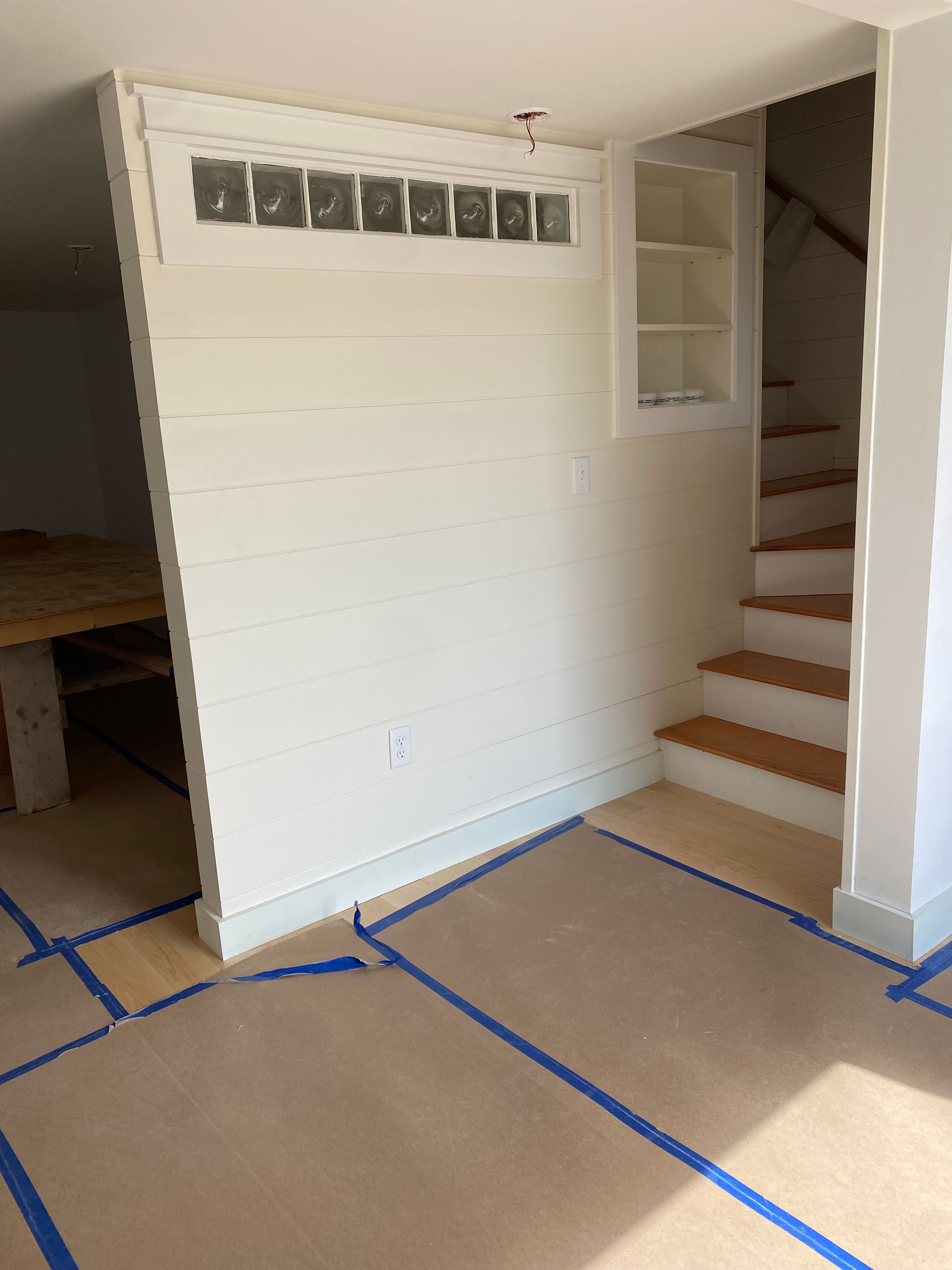 An empty room with stairs and a white wall