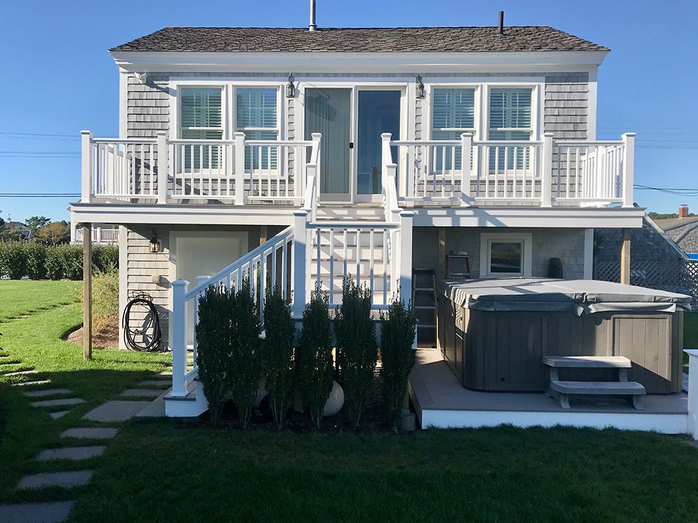 The back of a house with a hot tub on the deck