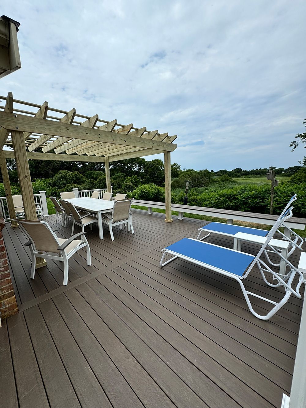 A deck with a table and chairs and a pergola