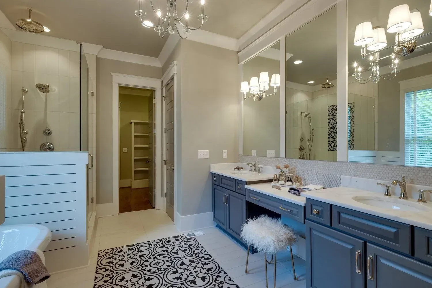 Bathroom with a double vanity, large mirrors, a shower, and a decorative rug. Gray and white color scheme.